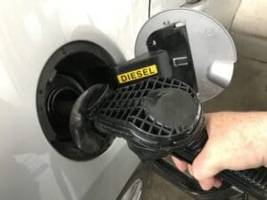 Person filling the car with diesel at the gas station, close-up.