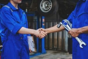 Auto mechanic handshake showing success collaboration of mechanics Check and maintain the engine for