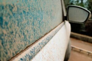 Detail of white cars very dirty from rains of mud, unwashed and neglected, covered in dust.